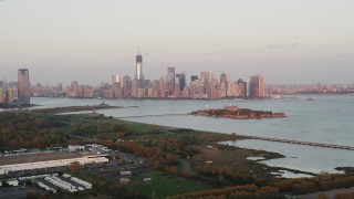 4K aerial stock footage Approaching Ellis Island, Lower Manhattan skyline, New York, New York, sunset Aerial Stock Footage | AX89_001