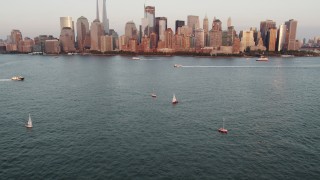 4K aerial stock footage of Sailboats, New York Harbor, revealing Lower Manhattan, New York, sunset Aerial Stock Footage | AX89_002