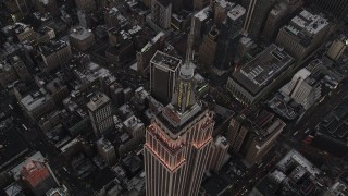 AX89_050 - 4K aerial stock footage of a Bird's eye view over Empire State Building, Midtown Manhattan, New York, twilight