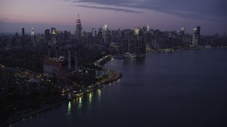 4K aerial stock footage Flying by Midtown Manhattan, seen from East River, New York, New York, twilight Aerial Stock Footage | AX89_113