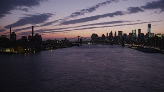 AX89_126 - 4K aerial stock footage Flying by Manhattan Bridge, Lower Manhattan skyline, New York, twilight