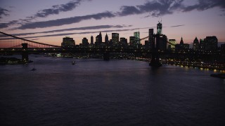 AX89_128 - 4K aerial stock footage Approaching Manhattan Bridge, Lower Manhattan skyline, New York, twilight