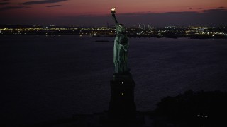 4K aerial stock footage Flying by the Statue of Liberty, Liberty Island, New York, New York, twilight Aerial Stock Footage | AX89_138