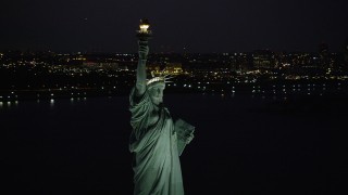 AX89_142 - 4K aerial stock footage Flying by the Statue of Liberty, Liberty Island, New York, New York, night