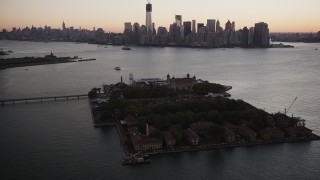 4K aerial stock footage Approaching Lower Manhattan skyline, Ellis Island, New York, New York, sunrise Aerial Stock Footage | AX90_002