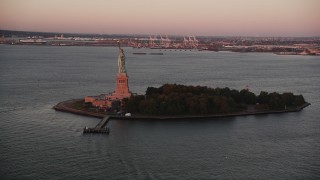 4K aerial stock footage Flying by Statue of Liberty, Liberty Island, New York, New York, sunrise Aerial Stock Footage | AX90_013