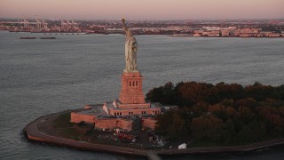 4K aerial stock footage Flying by Statue of Liberty, Liberty Island, New York, New York, sunrise Aerial Stock Footage | AX90_014