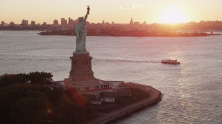 4K aerial stock footage Flying by Statue of Liberty, Brooklyn in the distance, New York, New York, sunrise Aerial Stock Footage | AX90_018