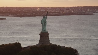 4K aerial stock footage Flying by Statue of Liberty, Brooklyn in the distance, New York, New York, sunrise Aerial Stock Footage | AX90_019