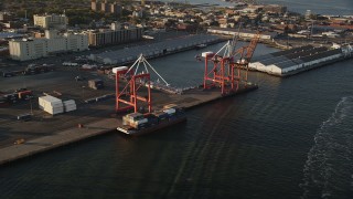 AX90_109 - 4K aerial stock footage Approaching cargo cranes, Brooklyn Cruise Terminal, Brooklyn, New York, sunrise