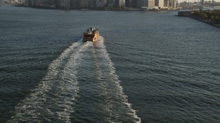 4K aerial stock footage Flying by Staten Island Ferry, tilt up to Lower Manhattan, New York, sunrise Aerial Stock Footage | AX90_130