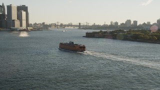 4K aerial stock footage Tracking the Staten Island Ferry near Lower Manhattan, New York, sunrise Aerial Stock Footage | AX90_131