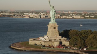 4K aerial stock footage Flying by Statue of Liberty, Liberty Island, New York Harbor, New York, sunrise Aerial Stock Footage | AX90_139