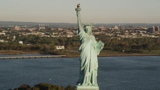 4K aerial stock footage Flying by Statue of Liberty, Liberty Island, New York Harbor, New York, sunrise Aerial Stock Footage | AX90_141