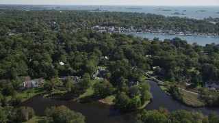 4K aerial stock footage of flying over riverfront mansions and trees toward Five Mile River, Norwalk, Connecticut Aerial Stock Footage | AX91_089