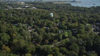 AX91_093 - 4K aerial stock footage of flying over trees and suburban homes in Norwalk, Connecticut