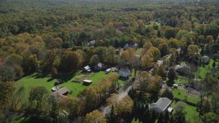 AX91_173 - 4K aerial stock footage of flying over forest and suburban homes, autumn, Guilford, Connecticut