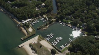 4K aerial stock footage of flying over a small marina beside a beach in Southold, New York Aerial Stock Footage | AX91_200