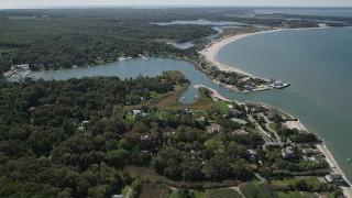 4K aerial stock footage approach Wooley Pond, tilt to upscale beachfront homes, Southampton, New York Aerial Stock Footage | AX91_205