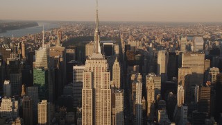 AX93_042 - 4K aerial stock footage Flying by the Empire State Building, Midtown Manhattan, New York, sunset