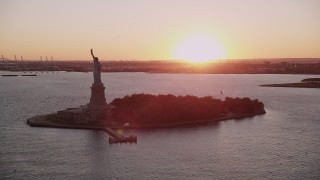 AX93_107 - 4K aerial stock footage Flying by the Statue of Liberty, New York, New York, sunset