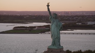 4K aerial stock footage Flying by Statue of Liberty, New York Harbor, New York, New York, sunset Aerial Stock Footage | AX93_113