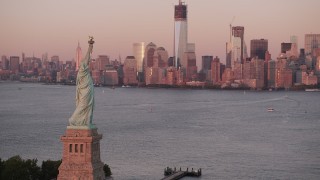 4K aerial stock footage of the Statue of Liberty, New York Harbor, Lower Manhattan, New York, sunset Aerial Stock Footage | AX93_116