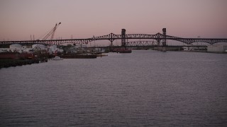 AX93_132 - 4K aerial stock footage of Industrial buildings, Lincoln Highway, Pulaski Skyway Bridges, Newark, New Jersey, twilight