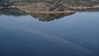 5K aerial stock footage of flying over Casitas Dam, tilt up to reveal hills on the shore of Lake Casitas, California Aerial Stock Footage | AXSF01_019