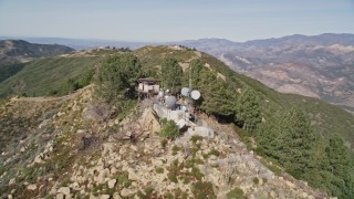 AXSF01_034 - 5K aerial stock footage orbit tree-lined slopes and radio tower, Santa Ynez Mountains, California