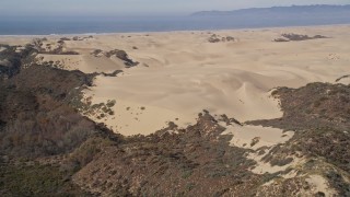 AXSF02_015 - 5K aerial stock footage of approaching sand dunes, ATV riders, Pismo Dunes, California