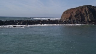 AXSF02_042 - 5K aerial stock footage fly low over San Luis Obispo Bay, breakwater, and pan to reveal a cliff, San Luis Obispo, California