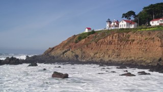 AXSF02_043 - 5K aerial stock footage fly over breakwater by coastal cliff, reveal San Luis Obispo Lighthouse, San Luis Obispo, California