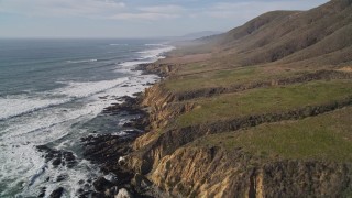 5K aerial stock footage tilt from crashing waves to coastline to reveal coastal cliffs, Cambria, California Aerial Stock Footage | AXSF03_023