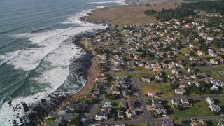 5K aerial stock footage of a bird's eye view of rugged coastal cliffs, tilt to homes near ocean, Cambria, California Aerial Stock Footage | AXSF03_026