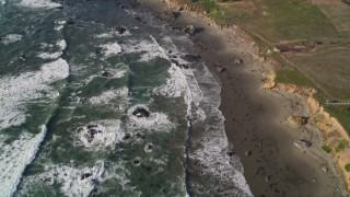 5K aerial stock footage tilt from ocean to reveal isolated beachfront mansion, Cambria, California Aerial Stock Footage | AXSF03_033