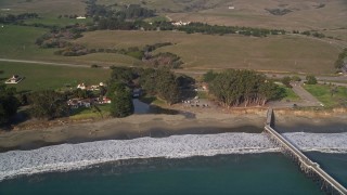 5K aerial stock footage Approach the beach by San Simeon Pier, and tilt to Spanish style buildings, San Simeon, California Aerial Stock Footage | AXSF03_046