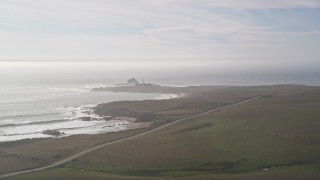 AXSF03_053 - 5K aerial stock footage approach Piedras Blancas Light Station from Highway 1 on Point Piedras Blancas, California