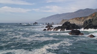 5K aerial stock footage of flying over rock formations and waves off the coast, San Simeon, California Aerial Stock Footage | AXSF03_059