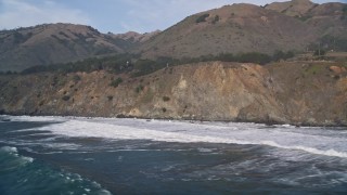 5K aerial stock footage of flying by waves rolling into coastal cliffs, San Simeon, California Aerial Stock Footage | AXSF03_061