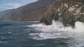 AXSF03_062 - 5K aerial stock footage pan across coastal cliffs and fly over ocean rock formation, San Simeon, California