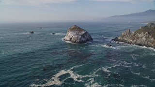 AXSF03_077 - 5K aerial stock footage approach and orbit a large rock formation off the coast, Big Sur, California