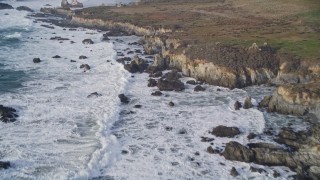 5K aerial stock footage tilt from ocean waves, approach rugged coastal cliffs, rock formations, Big Sur, California Aerial Stock Footage | AXSF03_082