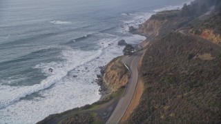 5K aerial stock footage of tilting from Highway 1 coastal road to cliffs to the coastline, reveal campground, Big Sur, California Aerial Stock Footage | AXSF03_087