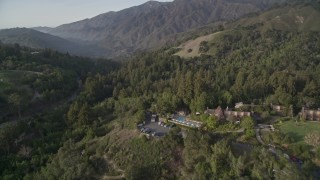 5K aerial stock footage of flying over Ventana Inn & Spa hotel, reveal highway through forest, Big Sur, California Aerial Stock Footage | AXSF03_102