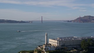 5K aerial stock footage tilt up to reveal and fly over Alcatraz, approach Golden Gate Bridge, San Francisco, California Aerial Stock Footage | AXSF05_069