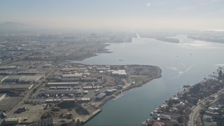 5K aerial stock footage follow the estuary over bridge and warehouses, approach San Leandro Bay, Oakland, California Aerial Stock Footage | AXSF05_089