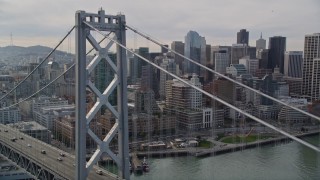 AXSF06_014 - 5K aerial stock footage track light traffic then fly over the Bay Bridge toward skyscrapers in Downtown San Francisco, California