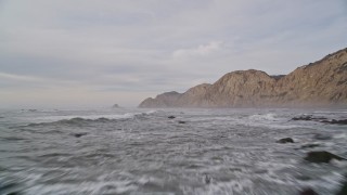 5K aerial stock footage of flying low over ocean and rocks near coastal cliffs, Bolinas, California Aerial Stock Footage | AXSF06_061