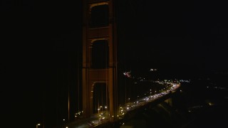 5K aerial stock footage of tilting from traffic on the Golden Gate Bridge to one of the towers and back, San Francisco, California, night Aerial Stock Footage | AXSF07_040